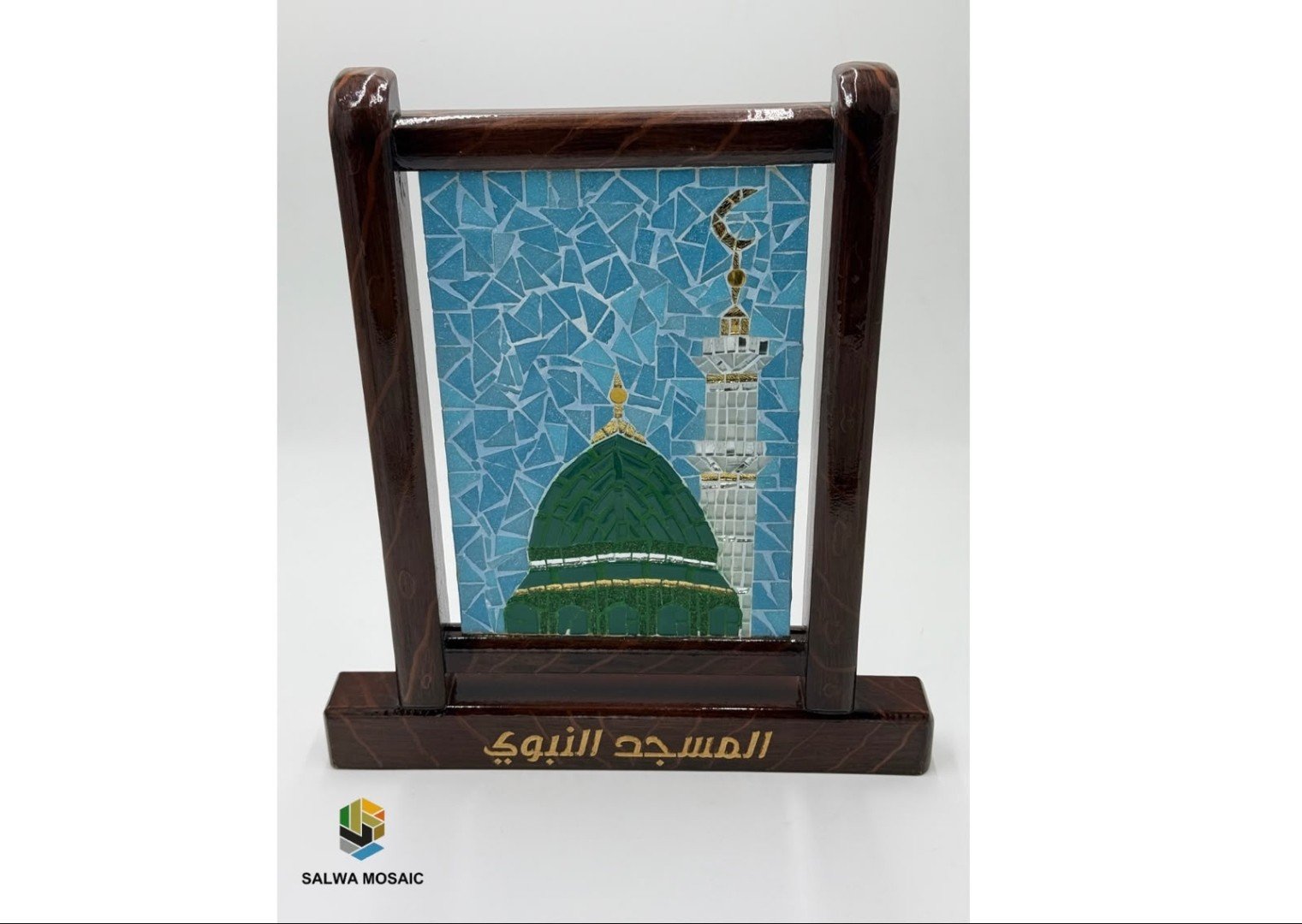 لوحة فسيفساء للقبة الخضراء ومنارة المسجد النبوي ضمن حامل خشبي يحمل شعار سلوى موزاييك